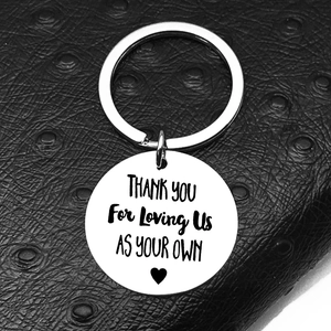 Detail of engraved stainless steel keychain with Thank You For Loving Us text on leather