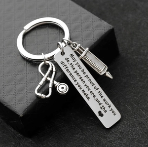 Detailed close-up of medical keychain with stethoscope and syringe on black gift box