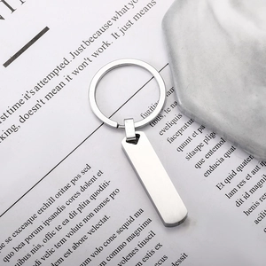 Minimalist silver stainless steel rectangular keychain with a brushed finish on paper