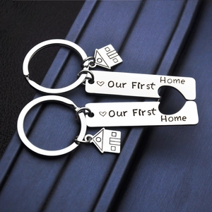 Polished stainless steel puzzle keychains with Our First Home engraving and house charms
