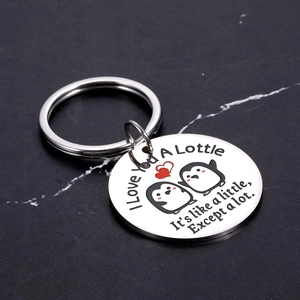 Polished stainless steel keychain featuring cute penguins and a red heart on marble