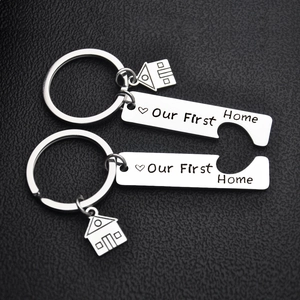Close-up of heart-shaped puzzle keychains engraved with Our First Home text