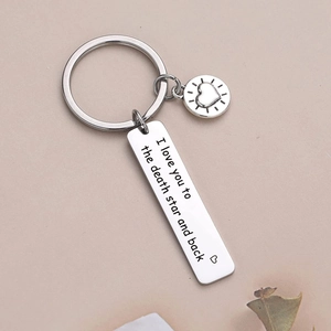 Polished stainless steel heart and bar keychain with I Love You engraving on pink surface