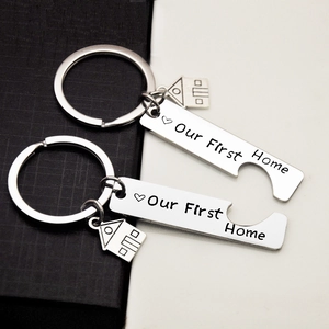 Detailed close-up of stainless steel puzzle keychains with Our First Home engraving