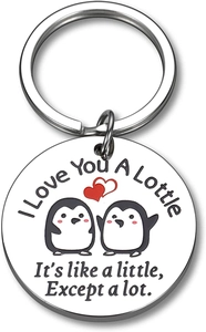 Detailed view of round stainless steel keychain with cute penguins and red heart design