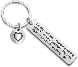 Detail of stainless steel rectangular keychain with heart cutout and romantic engraving