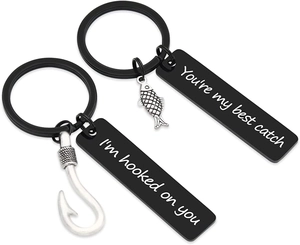 Vue détaillée du porte-clés couple noir avec pendentifs poisson et texte gravé