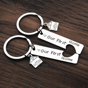 Polished stainless steel jigsaw keychain set with Our First Home engraving and house charms