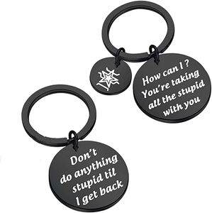 Close-up of black stainless steel keychains with laser-engraved American humor quotes