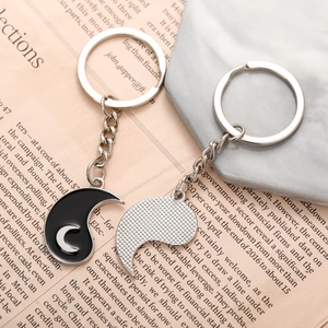 Yin Yang sun and moon couple keychain set on a vintage newspaper background