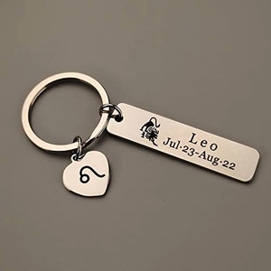 Macro shot of stainless steel Leo zodiac keychain with engraved date and heart charm