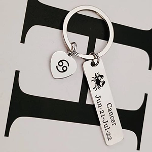 Close-up of Cancer zodiac keychain with engraved heart pendant and date details
