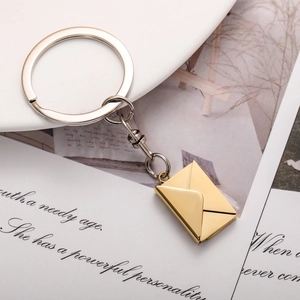 Macro shot of creative envelope-shaped gold pendant keychain on a minimalist background