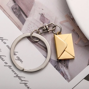 Polished gold envelope keychain with removable engraved card insert on magazine