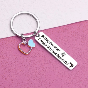 Macro detail of polished stainless steel dog groomer keychain with blue heart charm