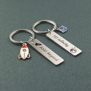 Matching rocket and planet stainless steel keychains with engraved space-themed slogans