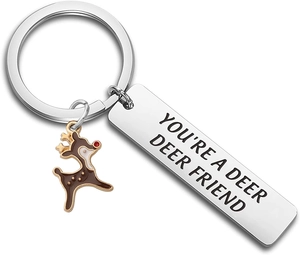 Détail macro du porte-clés en acier inoxydable avec texte gravé et charm de cerf mignon