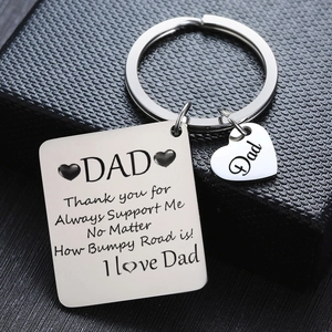Detailed close-up of custom silver stainless steel Dad keychain set on gift box background