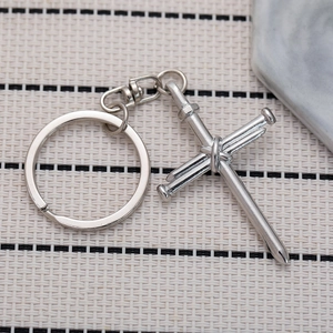 Silver metal cross keychain made of three crossed nails with industrial style design