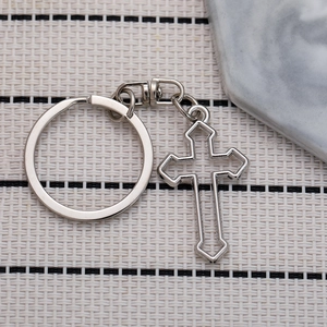Minimalist silver metal hollow cross keychain with polished finish on woven background