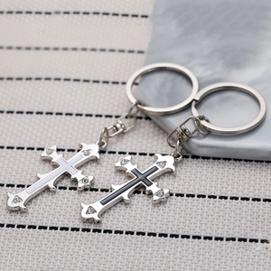 Detail of silver cross keychains with black and white inlay and sparkling crystal studs