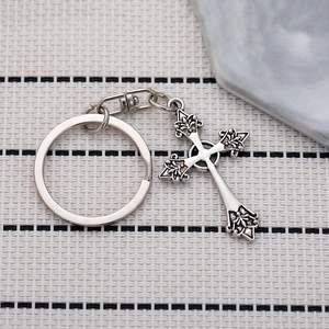 Porte-clés croix gothique en argent avec motifs floraux et texture métal vintage