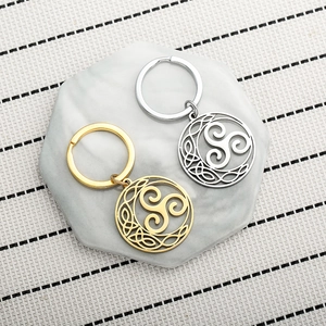 Polished stainless steel Celtic Knot keychains in gold and silver on a marble tray