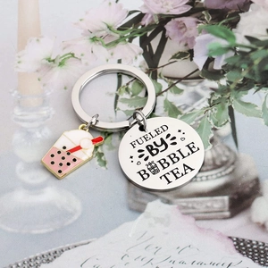 Detail of fueled by bubble tea engraving and colorful charm on stainless steel keychain