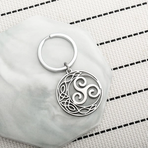 Polished silver stainless steel Triskelion Celtic knot keychain on a stone tray