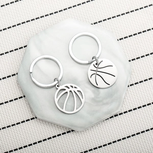 Detail von zwei silbernen Basketball-Schlüsselanhängern auf Marmor mit metallischem Finish