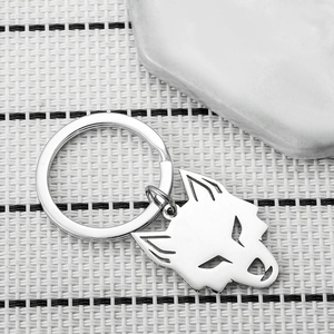 Polished stainless steel keychain featuring a hollow wolf head pendant on a textured surface