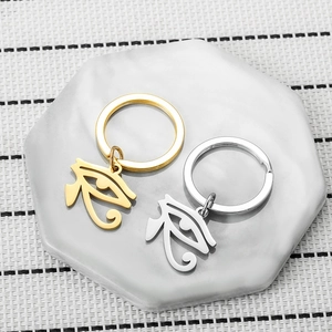 Golden and silver Eye of Horus stainless steel keychains on marble display tray