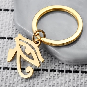Gold stainless steel Eye of Horus keychain with a polished mirror finish on a stone surface