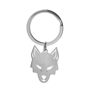 Detailed macro view of a silver hollowed-out wolf head keychain in polished stainless steel