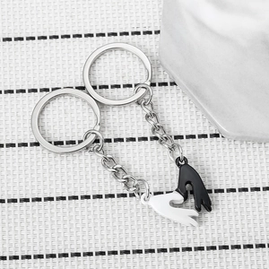 Close-up of magnetic heart-shaped hand-shaking pendants on minimalist textured surface