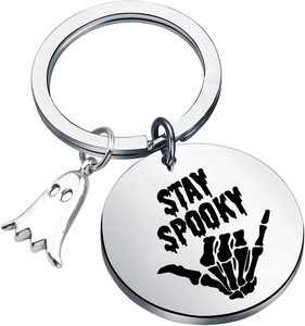 Detailed close-up of stainless steel Stay Spooky keychain with ghost charm and skull hand
