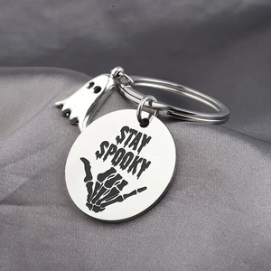 Stay Spooky stainless steel keychain featuring a skeleton hand and ghost charm for Halloween