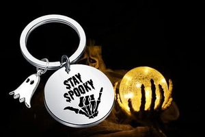 Detail of Stay Spooky stainless steel keychain with ghost charm on a bone-shaped holder