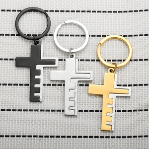 Three vintage cross keychains in black, silver, and gold with a unique metal splice design