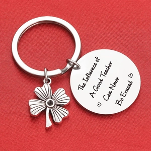 Clover stainless steel keychain with teacher appreciation engraving on red fabric background