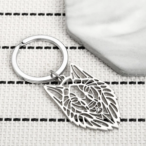 Porte-clés minimaliste en acier inoxydable avec tête de loup évidée sur fond blanc
