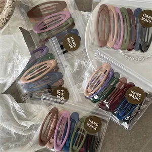 Set of matte oval BB hair clips in Morandi colors displayed on a textured background