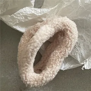 Detail shot of soft cream-colored sherpa fleece texture on a plush cloud hair claw clip