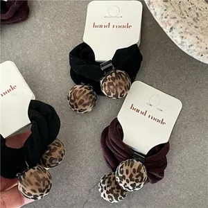 Set of leopard print ball hair ties in black and brown with handmade paper card
