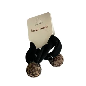 Two leopard print ball hair ties on a handmade card, black elastic ponytail holders