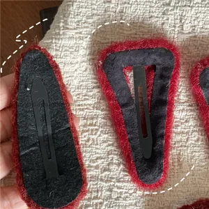 Close-up of red plush hair clip back with black metal duckbill clip and non-slip felt lining