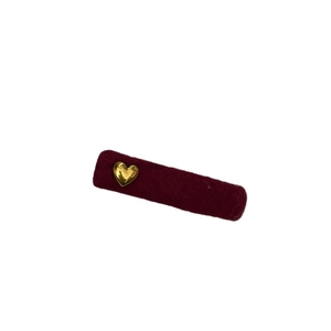 Sweet red velvet rectangular hair clip with a golden heart metal ornament on white surface