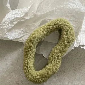 Detailed view of the olive green teddy plush hair scrunchie with soft fuzzy texture