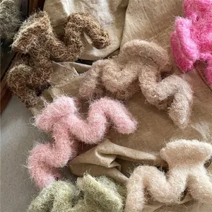 Pinces à cheveux en peluche ondulée aux couleurs pastel sur un fond en tissu lin