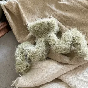 Détail d'une grande pince à cheveux en peluche vert clair avec design ondulé